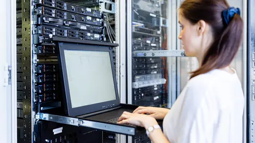 Symbolbild: Frau vor Computer und Server.