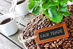 Kaffeebohnen, darauf ein Schild "Fairtrade"