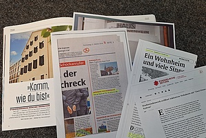 Auf dem Foto sieht man mehrere Zeitungsartikel zum Inklusionswohnheim Kaulbachstraße.
