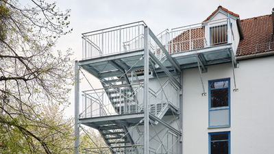 Die neue Feuerschutztreppe für den Kammermusiksaal des Wohnheims Notburgastraße außen am Gebäude bis ins Dachgeschoß.
