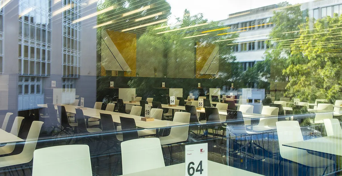 Bild einer Mensa, in den Fenstern spiegelt sich das Gebäude der LMU