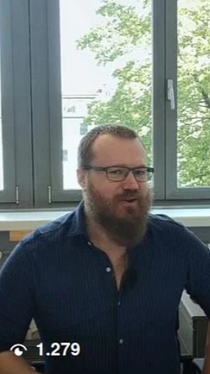 Auf dem Foto sieht man einen Mann, der seitlich in die Kamera blickt und gerade etwas sagt. Links unten die Ziffer "1279" mit einem Symbol von Instagram daneben, das die Anzahl der Aufrufe kennzeichnet.