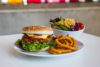Nahaufnahme eines Burgers mit Pommes und Salat