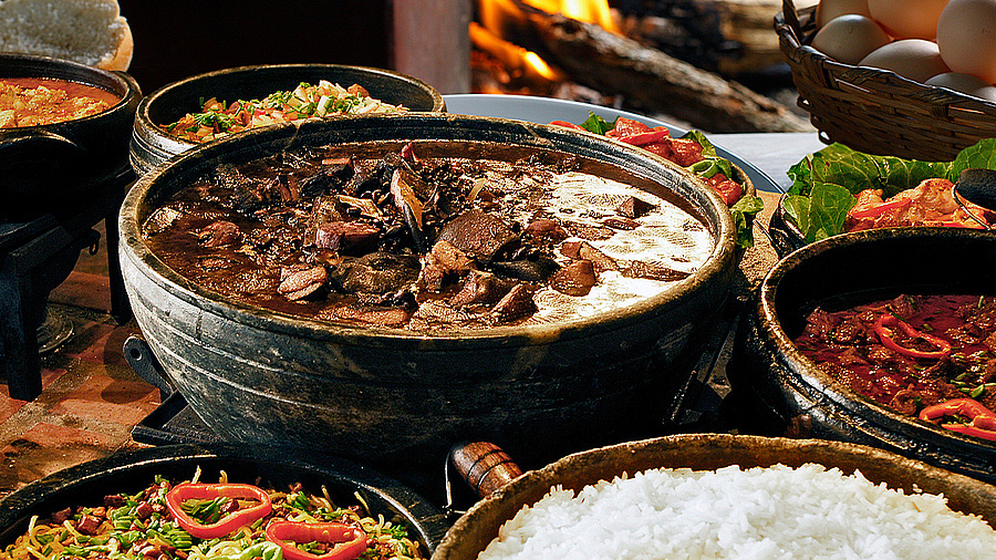 Das Bild zeigt einen Tisch, auf dem verschiedene Gerichte der brasilianischen Küche angerichtet sind.