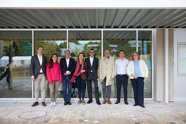 Gruppenfoto von 8 Personen im Eingansbereich eines Gebäudes