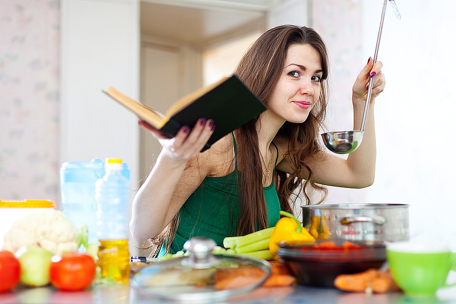 Rezeptesammlung Eine Frau hält eine Suppenkelle in der Hand.
