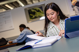 Studentin beim Lernen. Sie ließt in Büchern.