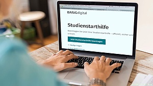 [Translate to English:] Symbolbild mit Laptop, auf dem die Startseite für die Studienstarthilfe von bafoeg-digital.de. 